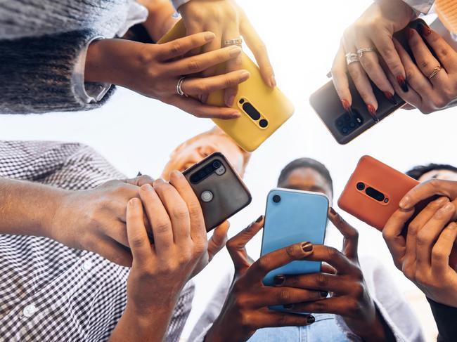 Teens in circle holding smart mobile phones - Multicultural young people using cellphones outside - Teenagers addicted to new technology concept