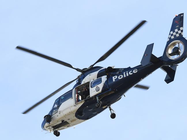 A Police Helicopter circles crime scene with a photographer aboard above Royal Park, Melbourne, Saturday, May 25, 2019. A woman's body has been found at Parkville in Melbourne's inner north. She was discovered near tennis courts on Elliott Avenue about 9.15am on Saturday. Police say they're yet to determine cause of death for the woman, who has not been identified. (AAP Image/James Ross) NO ARCHIVING