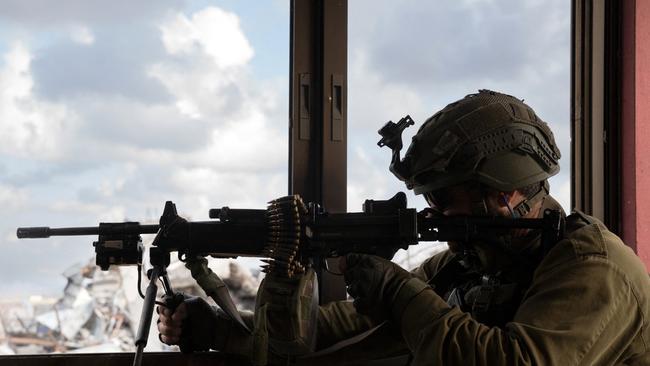 An Israeli soldier aiming a machine gun in a building as part of the activity of the 99th Division in the Zaytoun Area of Gaza. Picture: AFP