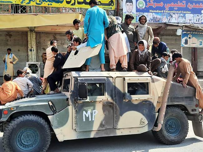 Taliban fighters and local residents on an Afghan National Army humvee vehicle in Laghman province. Picture: AFP