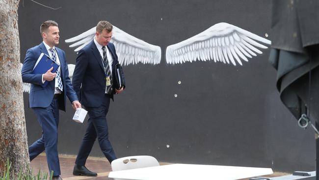 Detectives walk past the scene of the shooting in Keilor, where bullet holes serve as a stark reminder of the slaying. Picture: David Crosling