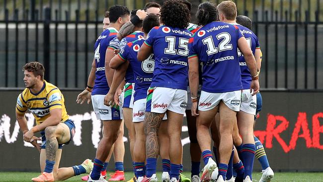 Chanel Harris-Tavita is mobbed by his Warriors teammates after scoring a try Picture: Getty Images