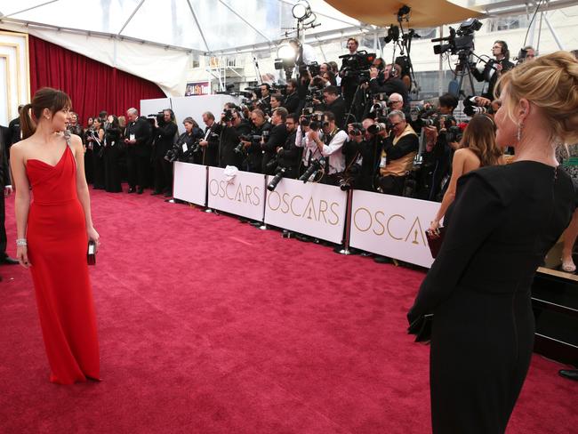 Dakota Johnson poses for photographers as her mother Melanie Griffith looks on.