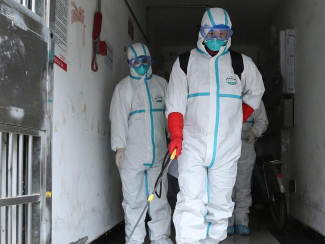 TOPSHOT - This photo taken on January 25, 2020 shows staff members wearing protective clothing disinfecting a residential area in Ruichang, part of Jiujiang in China's central Jiangxi province next to Hubei province, following the virus outbreak in Hubei's city of Wuhan. - China on January 27 extended its biggest national holiday to buy time in the fight against the viral epidemic, as the death toll spiked to 81 despite unprecedented quarantine measures and travel lockdowns. (Photo by STR / AFP) / China OUT