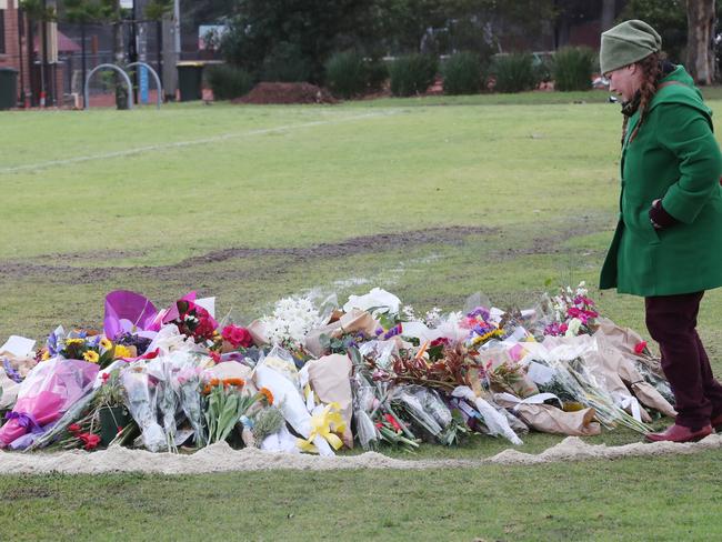 People continue to visit and drop off flowers at the makeshift memorial to Eurydice Dixon in Princes Park.  Picture: David Crosling