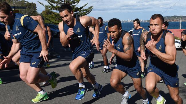 Wallabies players (lt-rt) Bernard Foley, Matt Toomua, Will Genia and Quade Cooper doing hill sprints during their final training session at Little Manly Beach in Sydney, Friday, Aug. 28, 2015. The Wallabies fly out tomorrow for the Rugby World Cup in England. (AAP Image/Dean Lewins) NO ARCHIVING