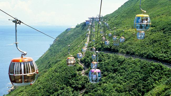 Cable cars set between two mountain peaks at Ocean Park, Hong Kong. The cable car ride provides stunning views of the south side of Hong Kong Island and the surrounding South China Sea.