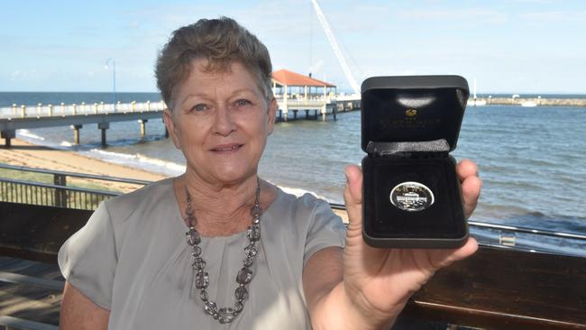 Redcliffe Historical Society member Rae Frawley pictured with the third limited edition coin celebrating 200 years since settlement in Redcliffe.