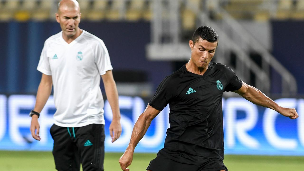 Real Madrid's French head coach Zinedine Zidane (L) looks on as Real Madrid's forward Cristiano Ronaldo shoots