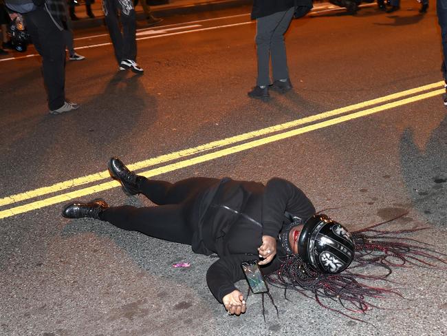 A Black Lives Matter campaigner bleeds from the mouth as she lays in the middle of the street during a pro-Trump protest. Picture: AFP