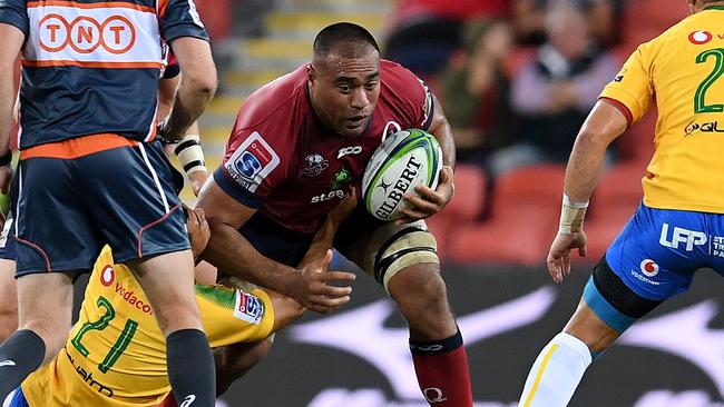 Caleb Timu of the Reds is tackled at Suncorp Stadium in Brisbane.