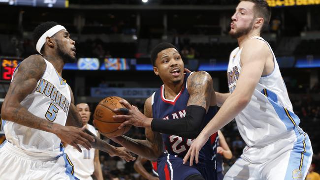 Atlanta Hawks guard Kent Bazemore drives the lane between Denver Nuggets forwards.