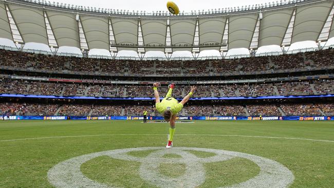 Umpire Nick Foot practices a centre bounce.