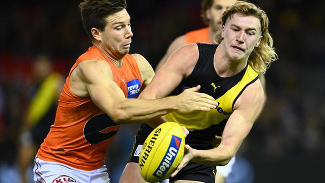 MELBOURNE, AUSTRALIA - MAY 15: Hugo Ralphsmith of the Tigers handballs whilst being tackled by Toby Greene of the Giants during the round 9 AFL match between the Richmond Tigers and the Greater Western Sydney Giants at Marvel Stadium on May 15, 2021 in Melbourne, Australia. (Photo by Quinn Rooney/Getty Images)