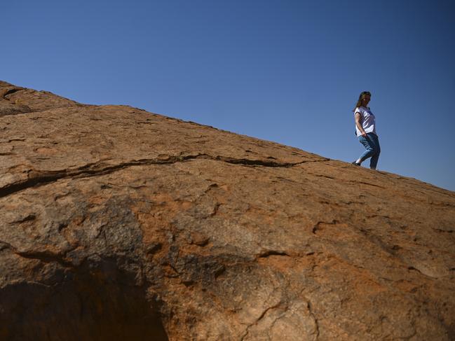 A tourist is seen coming down Uluru, also known as Ayers Rock at Uluru-Kata Tjuta National Park in the Northern Territory, Friday. Picture: AAP