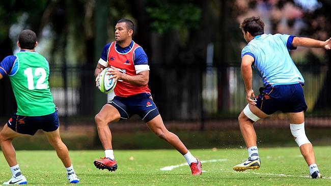 Back in blue, Kurtley Beale jinks between defenders at Waratahs training at Moore Park.