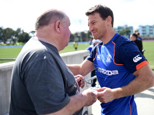 Brent Harvey signs autographs during training. Picture: Tracey Nearmy/AAP