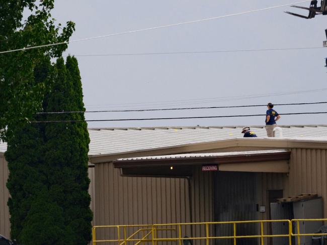 BUTLER, PENNSYLVANIA - JULY 14: Two FBI investigators scan the roof of AGR International Inc, the building adjacent to the Butler Fairgrounds, from which alleged shooter Matthew Thomas Crooks fired at former President Donald J. Trump, in the aftermath of the attempted assassination at a campaign rally on July 14, 2024 in Butler, Pennsylvania. Trump was escorted away by the Secret Service with an injury to his ear. One attendee at the rally on July 13 was killed and two others severely injured.   Jeff Swensen/Getty Images/AFP (Photo by JEFF SWENSEN / GETTY IMAGES NORTH AMERICA / Getty Images via AFP)