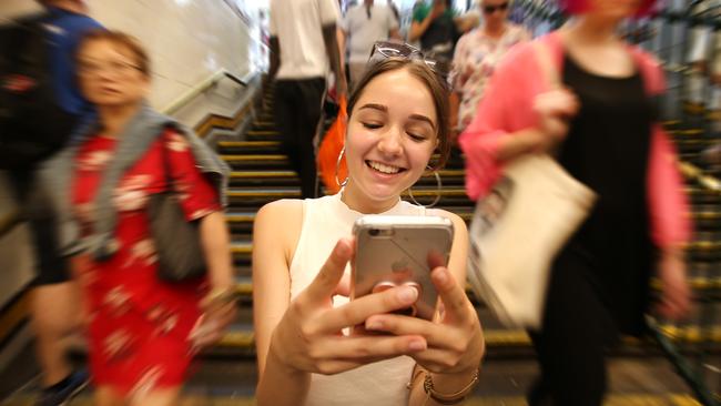 Sofia catches up on her social pages using her mobile phone while the world moves around her. Picture: David Caird