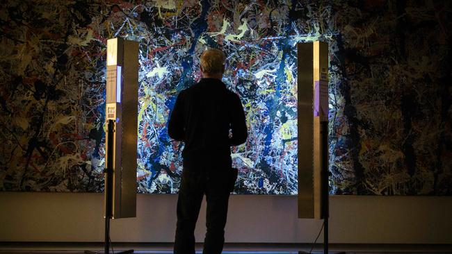 David Wise, Senior Paintings Conservator at the National Gallery of Australia, inspects Jackson Pollock’s Blue Poles under ultra violet light in situ at the gallery in Canberra, 27 May 2020. Picture by Sean Davey.