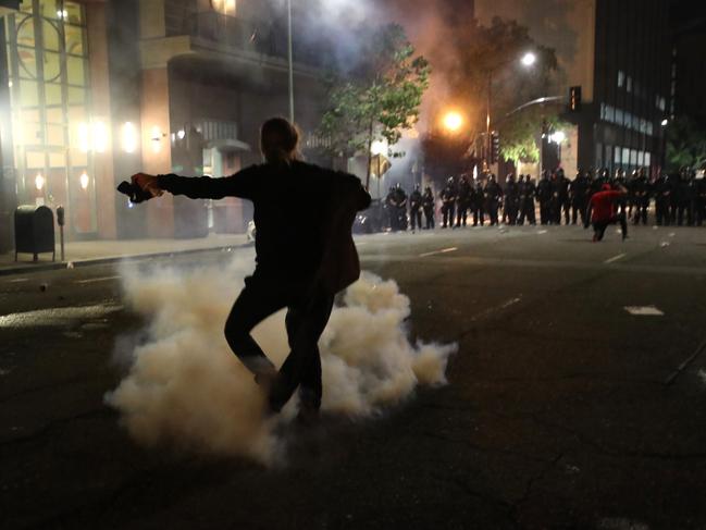 A demonstrator runs through tear gas that was deployed by police officers in Oakland, California. Picture: Getty