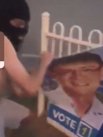 One of the offenders rips down a sign belonging to Southport MP Rob Molhoek.