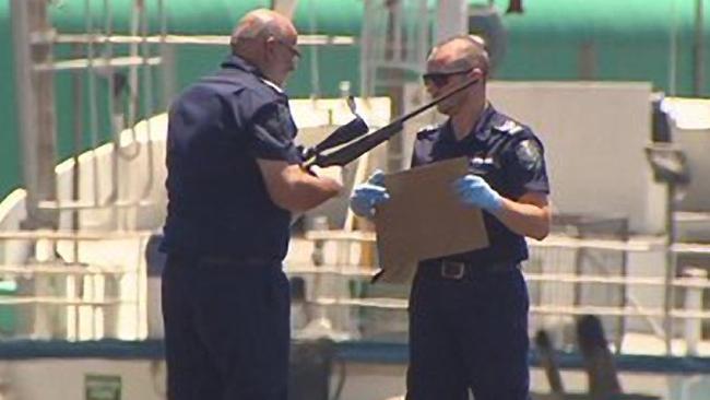 Police recover a rifle from the water, after the car plunged over the wharf. Picture: Channel 7