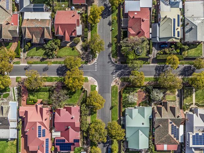 Aerial view of leafy eastern suburban houses on 4-way cross road intersection in Adelaide, South Australia: directly above, rooftop solar, trees. Housing property generic