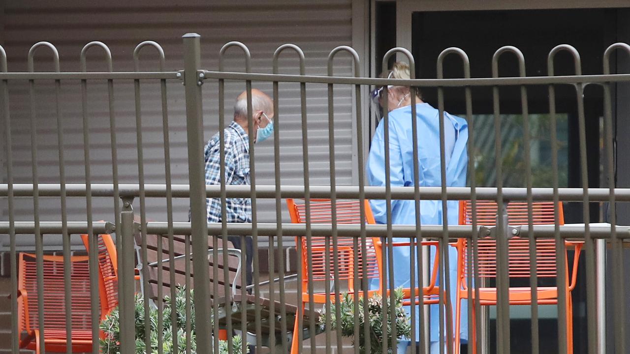 Pictured at Newmarch Nursing Home at Caddens in Sydney is an elderly resident being escorted by a staff member. The care home has had 11 COVID-19 related deaths. Picture: Richard Dobson