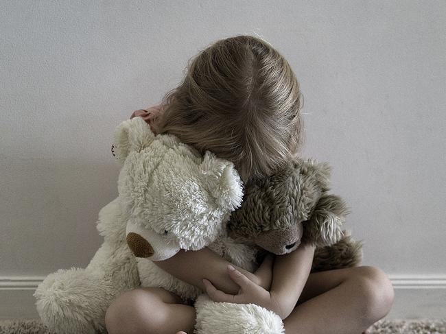 A little girl hugging stuffed toys in Brisbane, Tuesday, March 25, 2014. (AAP Image/Dave Hunt) NO ARCHIVING