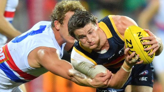 ON THE RISE: Emerging Crows midfielder Matt Crouch evades the tackle of Bulldog Mitch Wallis. Picture: David Mariuz (AAP).