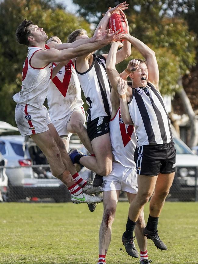 OEFL: Narre Warren and Olinda-Ferny Creek players fly for the mark. Picture: Valeriu Campan