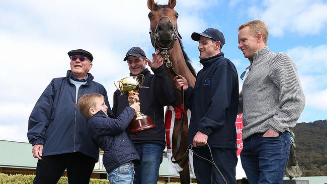 Frank Williams holds the Melbourne Cup for Almandin as his grandfather Lloyd Williams, trainer Robert Hickmott, strapper Joel Flannery and jockey Kerrin McEvoy gather at Macedon Lodge. Picture: Ian Currie