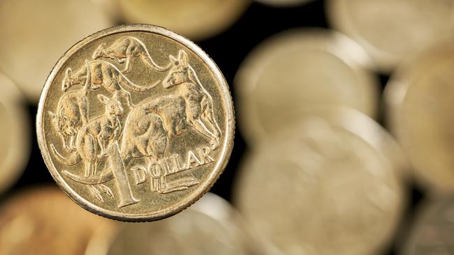 Australian one dollar coin over blurred golden background.