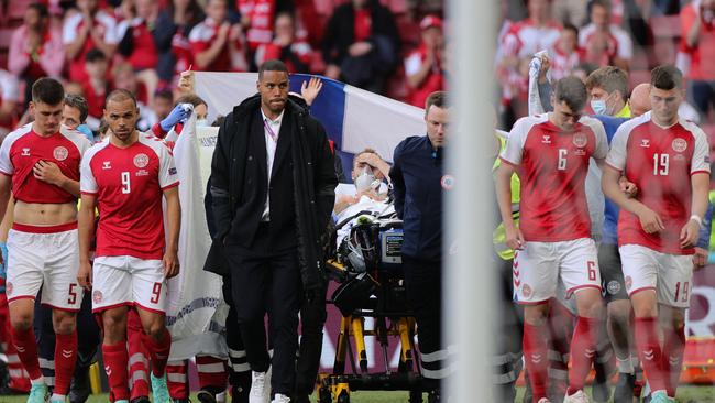 Christian Eriksen is wheeled off the pitch, and bound for hospital after CPR in the wake of his collapse. Picture: Friedemann Vogel / various sources / AFP