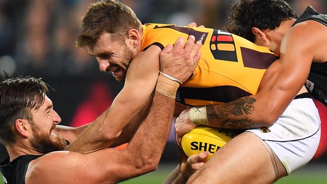 GOT YA: Port Adelaide’s Charlie Dixon and Brendon Ah Chee bring down Hawk Brendon Whitecross. Picture: Daniel Kalisz (Getty)