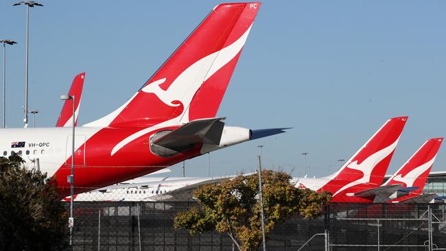 Qantas planes sit parked on a tarmac next to the Brisbane International Airport. Picture: NCA NewsWire/Jono Searle