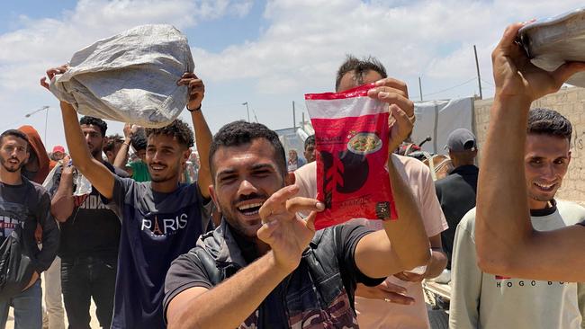 Displaced Palestinians react as they display items received from an aid distribution centre in Khan Yunis. Picture: AFP