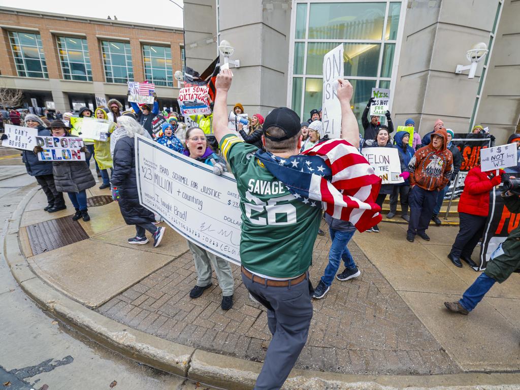 Protesters yell at a man with an American flag outside Elon Musk’s town hall meeting. Picture: AP