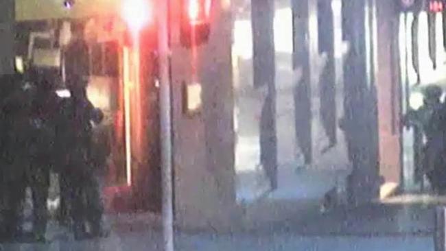 This image from CCTV footage of the Lindt Cafe Siege shows hostage Louisa Hope standing in the middle of the stronghold, illuminated in the explosions as police stormed the building. Picture: Supplied