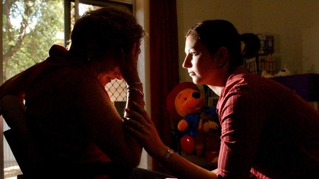 An abuse victim is comforted at a domestic violence support organisation.