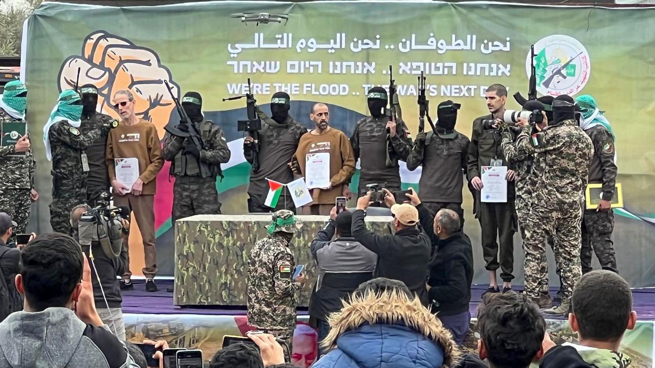 Palestinian Hamas fighters escort Israeli hostages (L-R) Ohad Ben Ami, Or Levy and Eli Sharabi on a stage before handing them over to a Red Cross team in Deir el-Balah, central Gaza. Picture: Bashar TALEB / AFP