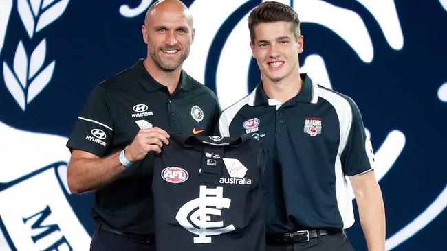 Liam Stocker (right) receives his Carlton jumper from Chris Judd on draft night.