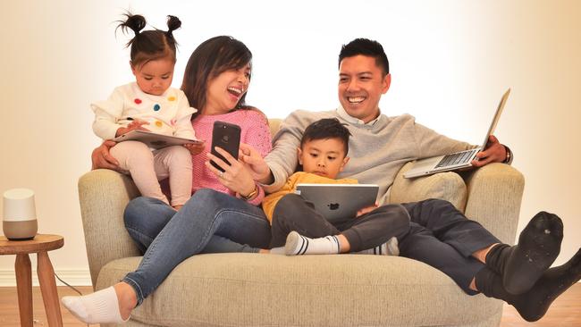 Jacqui and Wesley Yuan with children Hanna, 2 and Daniel, 5, and the family’s tech devices. Picture: Tony Gough