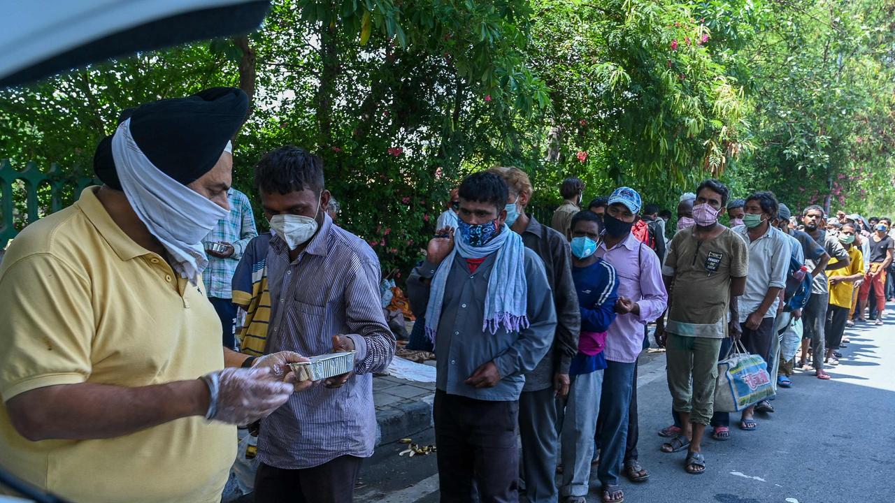 Men queue to work for food as volunteers in New Delhi during lockdown joblessness. Picture: Prakash Singh/AFP