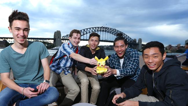 Sydney students Nathan Sammut, 15, Kristopher Meyer, 15, Keenan Forster, 16, Matthew Ling, 15, and Bryan Chang, 15, playing Pokemon Go at Sydney Harbour. Picture: Britta Campion / The Australian.