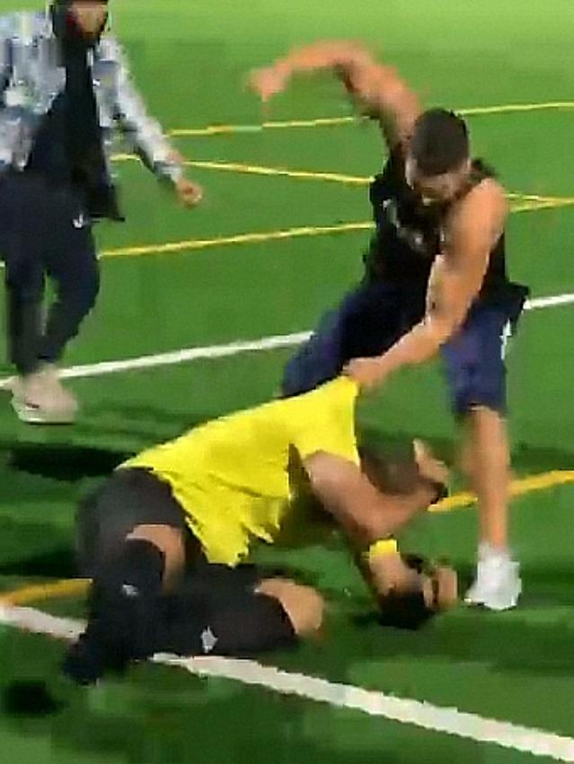 The suspended player can be seen repeatedly kicking and punching the referee. Picture: video screengrab