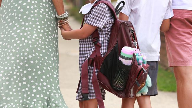 A parent walks a young student to school. Picture: AAP