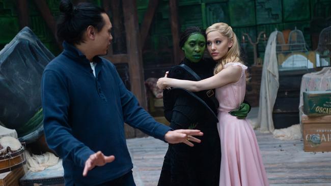 Wicked director Jon M. Chu with Cynthia Erivo as Elphaba and Ariana Grande as Glinda.