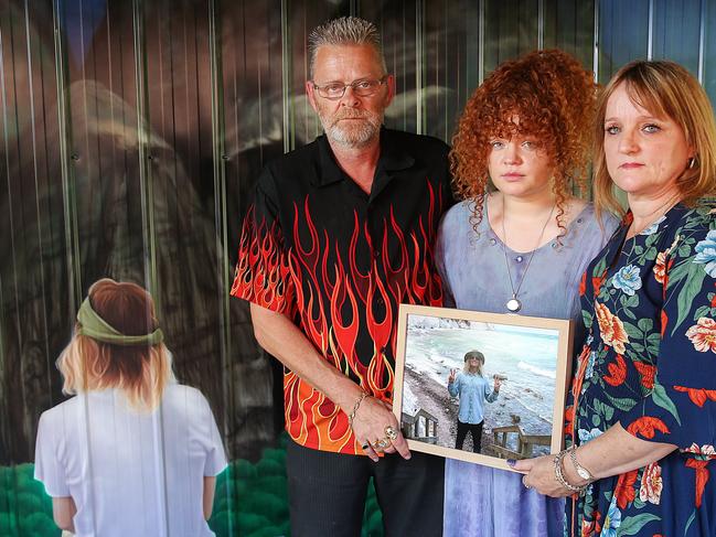 Lee, Tiarnie and Debbie Brasher with a mural of Corey. Picture: Ian Currie